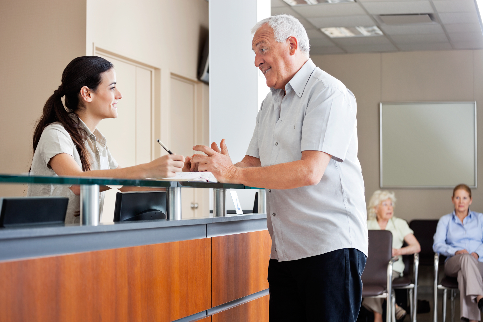 patient engaging with receptionist at medical office